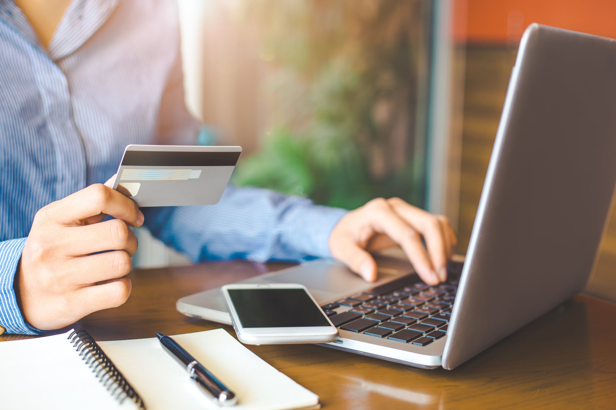 Woman holds a credit card and buys something online